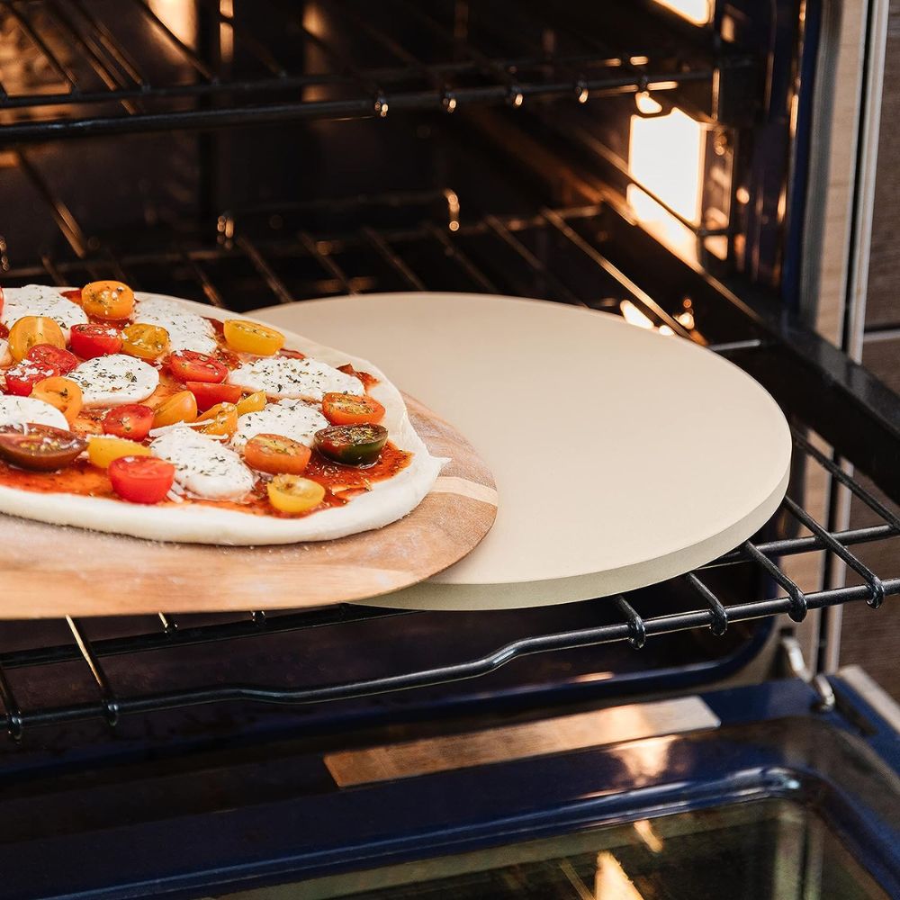 launching pizza using a wooden peel into the pizza stone in an oven