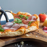 Cutting pizzza on All Natural Acacia Wooden Pizza Peel - Chef Pomodoro